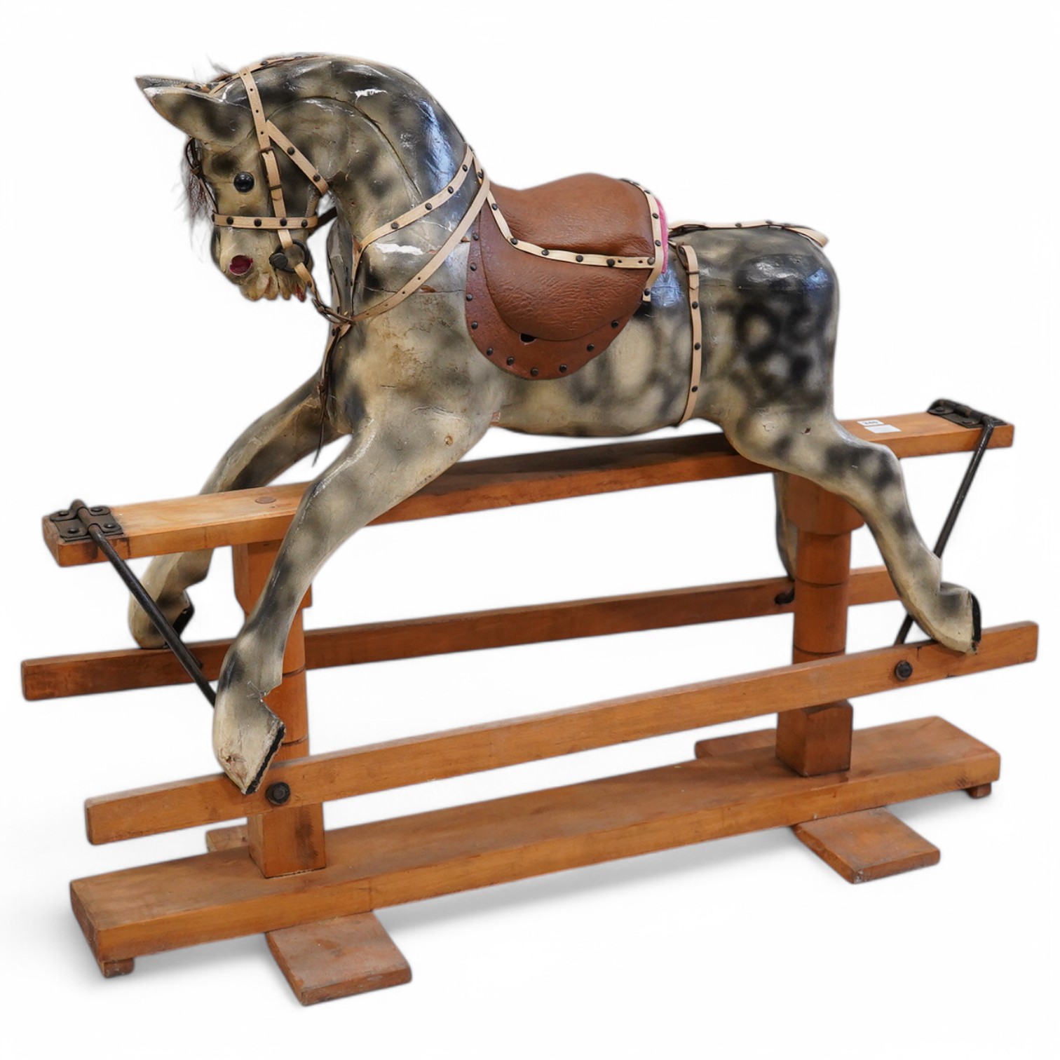 An early 20th century dapple grey rocking horse, on later trestle base, length 132cm. Condition - fair.